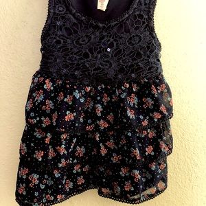 Girls ruffled crop top, navy blue w/floral pattern on bottom half. Sleeveless.